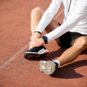 Man with injured foot and ankle on the running track.
