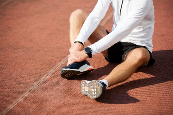 Man with injured foot and ankle on the running track. 